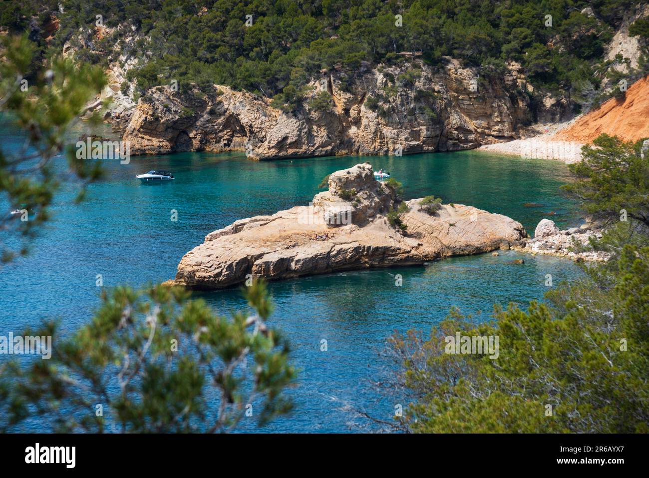 People sunbathe on Galley rock or Submarine rock. View  from hiking path near Calanque de Port d'Alon (between Saint-Cyr-sur-Mer and Bandol), France. Stock Photo