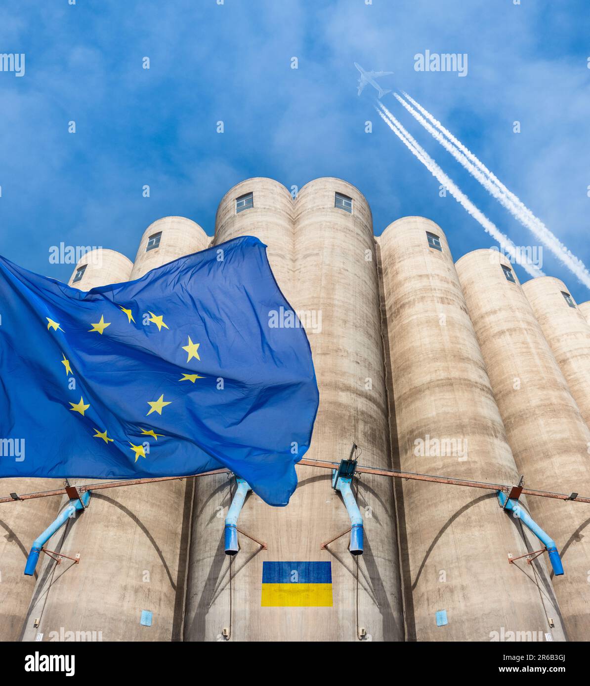 EU, European Union flag over grain silos with Ukraine flag. Ukraine, Russia war, world food prices, wheat prices, EU ban...concept Stock Photo