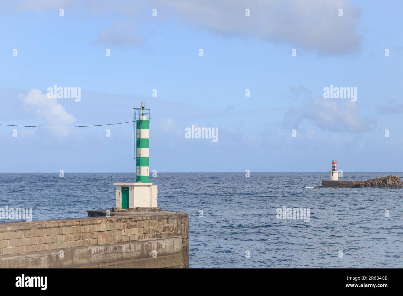 Lighthouses at the entrance to the Bay of Pasaia, Spain. Beacon, pharos, screed, seamark. Ocean bay, sunny, cloudy sky. Stock Photo
