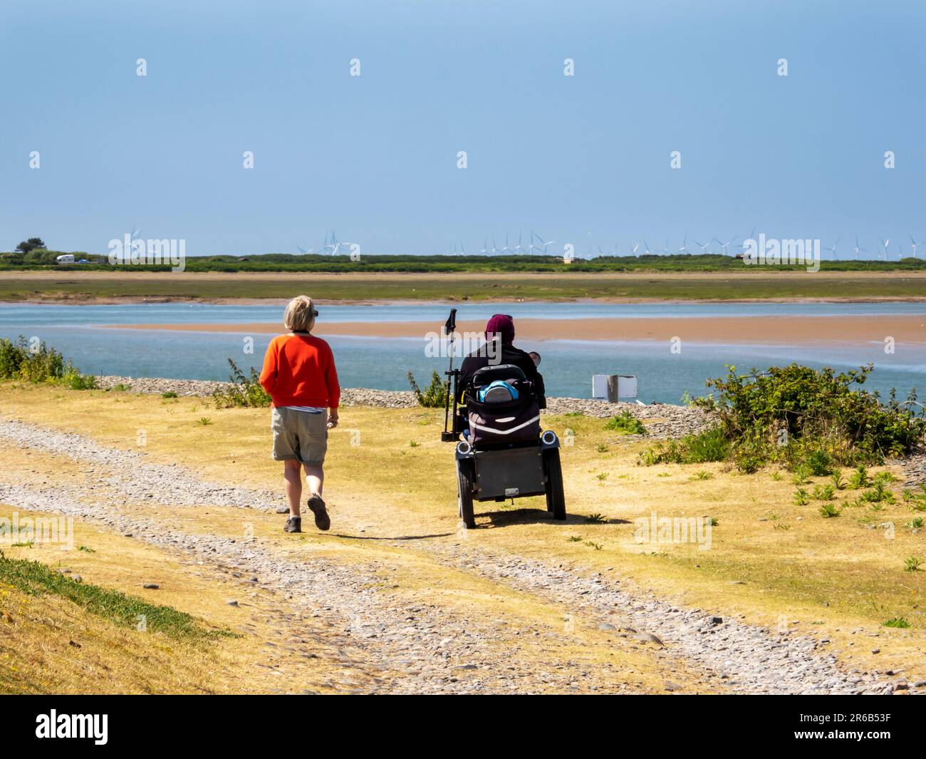 A couple with a man on a mobility scooter on Walney Island, Cumbria, UK. Stock Photo