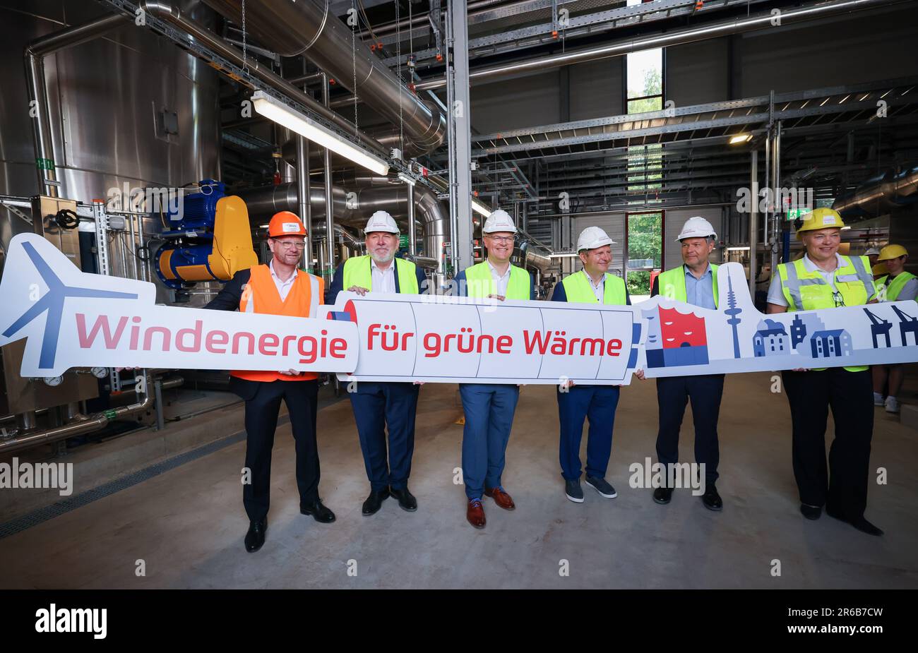 08 June 2023, Schleswig-Holstein, Wedel: Stefan Kapferer (l-r), head of the transmission system operator 50Hertz, Gernot Kaser (independent), Mayor of Wedel, Tobias Goldschmidt (Bündnis 90/Die Grünen), Minister for Energy Transition, Climate Protection, Environment and Nature in Schleswig-Holstein, Jens Kerstan (Bündnis 90/Die Grünen), Senator for Environment, Climate, Energy and Agricultural Economics in Hamburg, Robert Habeck (Bündnis 90/Die Grünen), Federal Minister for the Economy and Climate Protection, hold signs with the text 'Wind energy for green heat' at a press event to mark the com Stock Photo