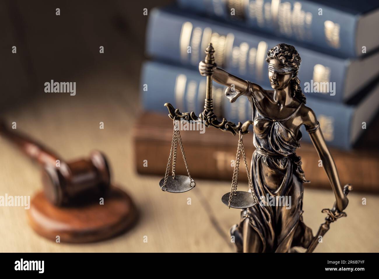 Statute of Justice and law books in the background. Stock Photo