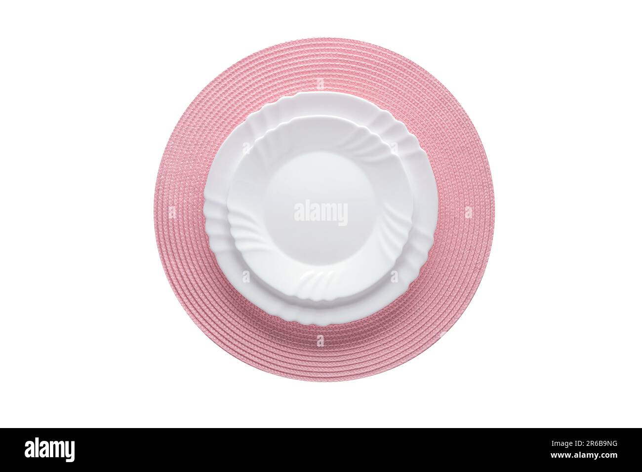 Empty white plate on a round pink woven napkin. The object is isolated on a white background. View from above. Flat lay design. Top view. Festive tabl Stock Photo