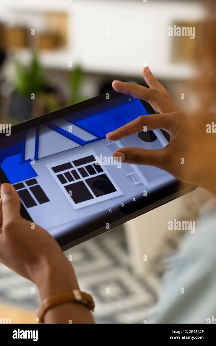 Hands of biracial woman at home using tablet with smart home interface ...