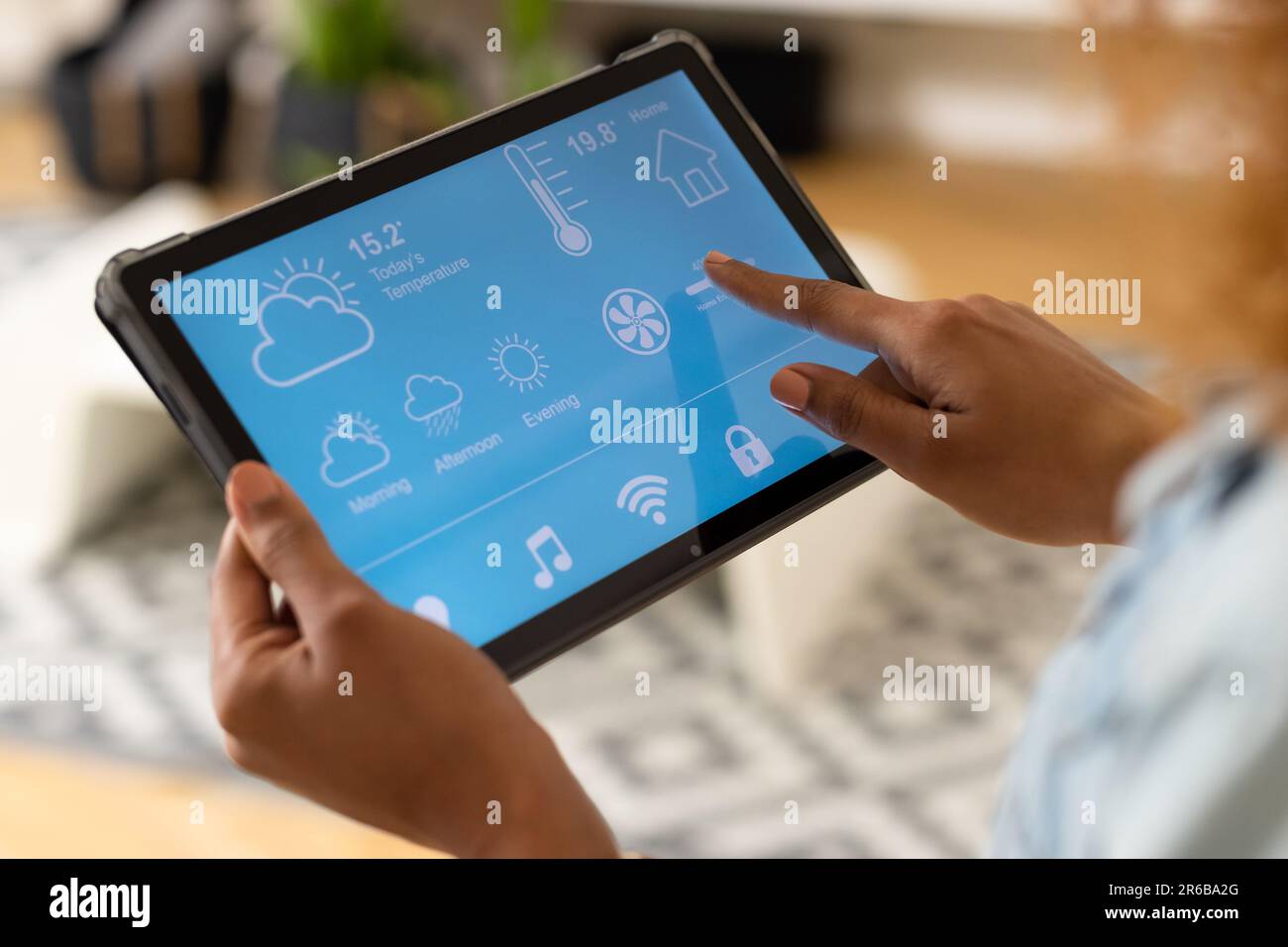 Hands of biracial woman in living room at home using tablet with smart ...