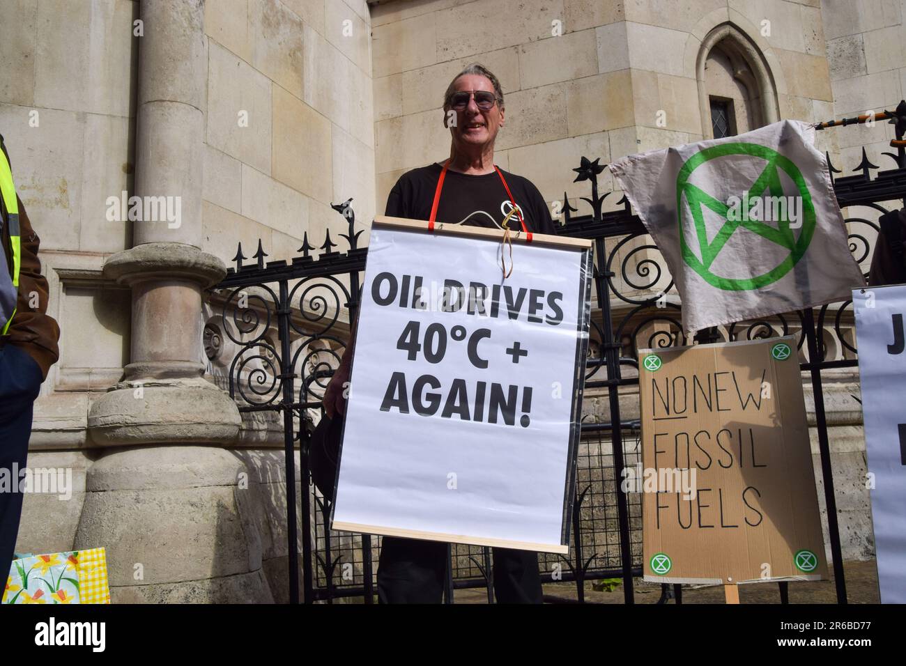 London, UK. 08th June, 2023. A protester holds a placard which states 'Oil drives 40 degrees again' during the demonstration. Climate protesters gathered outside the Royal Courts of Justice during the judicial review of the planning permission for UK Oil And Gas to explore for fossil fuels near the village of Dunsfold. Credit: SOPA Images Limited/Alamy Live News Stock Photo