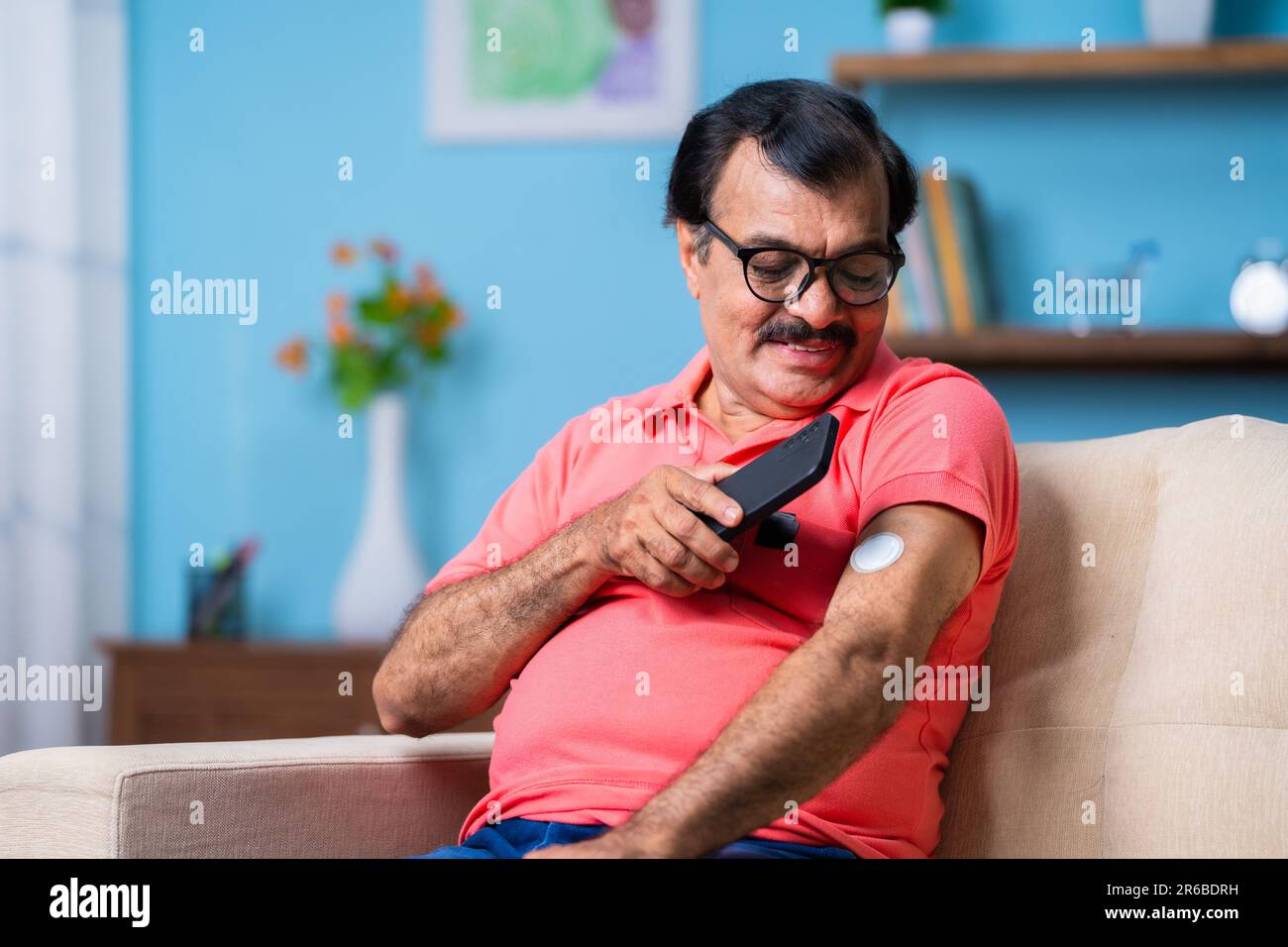 Elderly senior man checking glucose level by tapping smartphone to