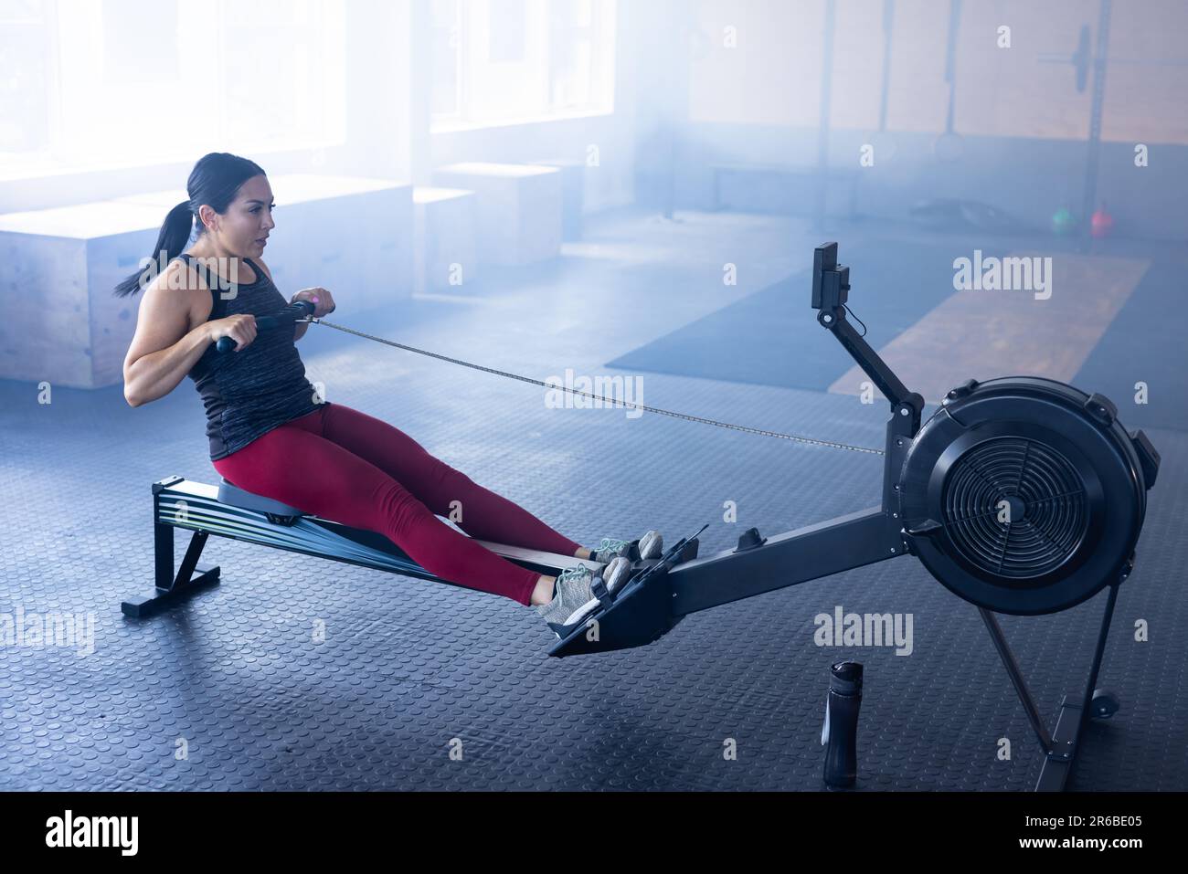 Young woman exercising rowing machine hi-res stock photography and ...