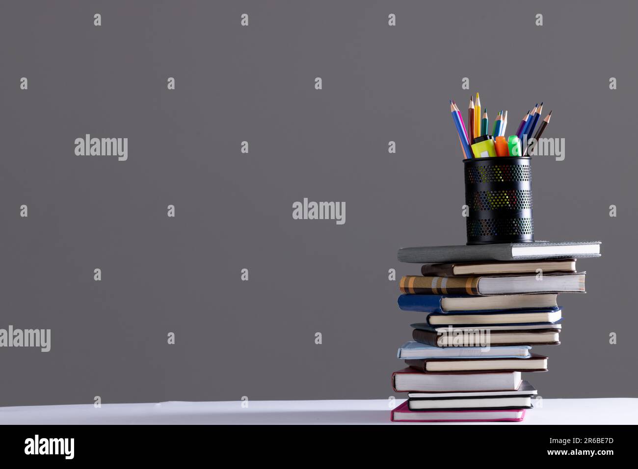 Stack of books and notebooks with pencil container on top and copy ...