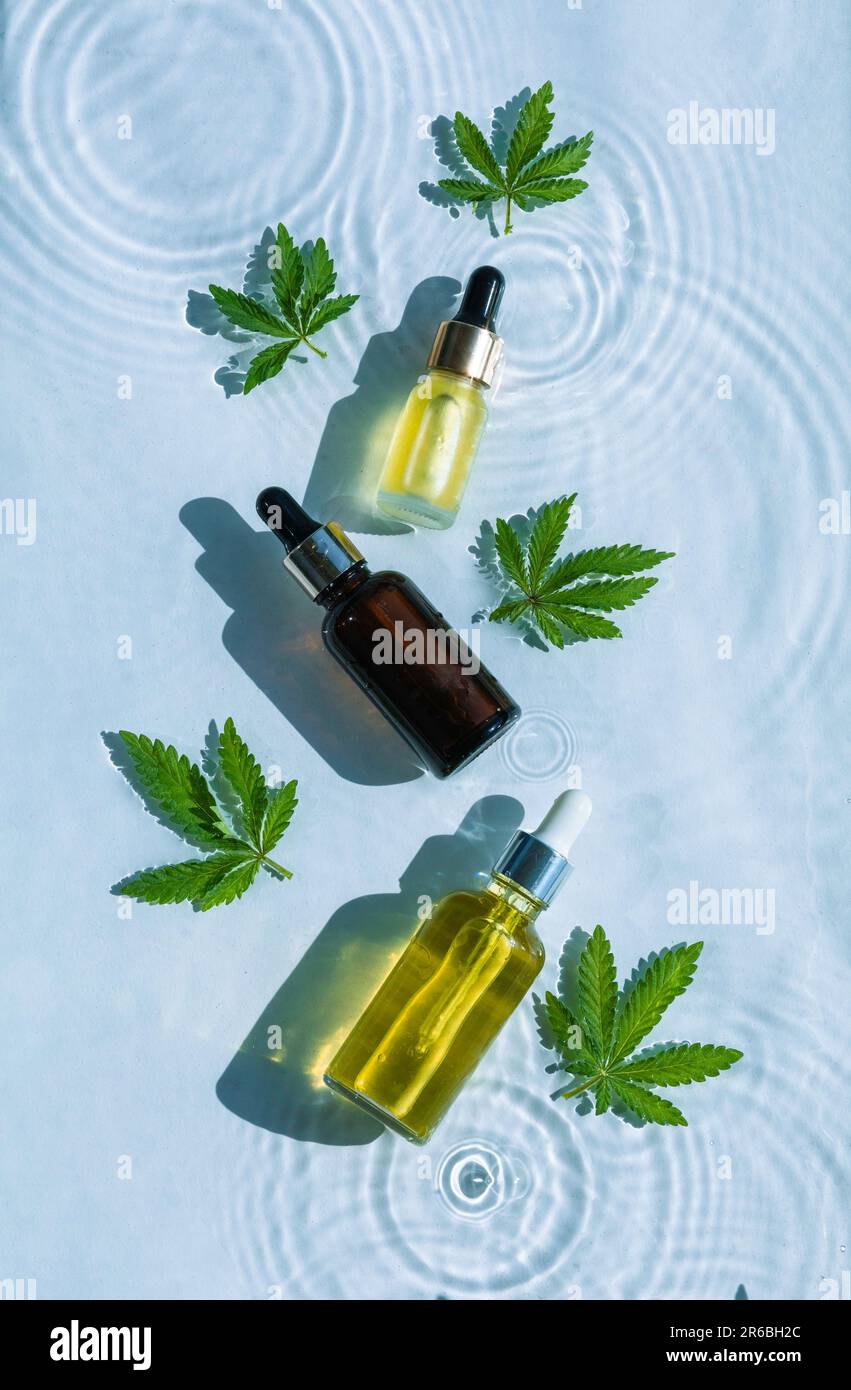 Cbd Oil Bottles, Blue water background with drops, waves and leaves of  hemp, marijuana. Flat lay, top view Stock Photo - Alamy