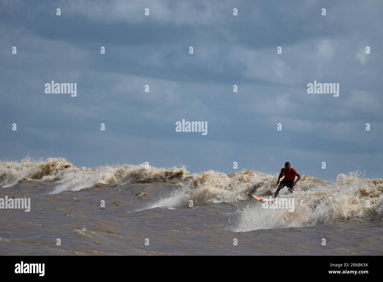 Brazilian surfer Naysson Costa rides the tidal bore wave known as