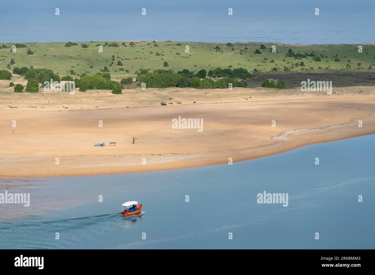 A solitary boat in the still waters of the lagoon at the Sidi Moussa-Oualidia RAMSAR protected wetlands near the town of Oualidia in Morocco Stock Photo