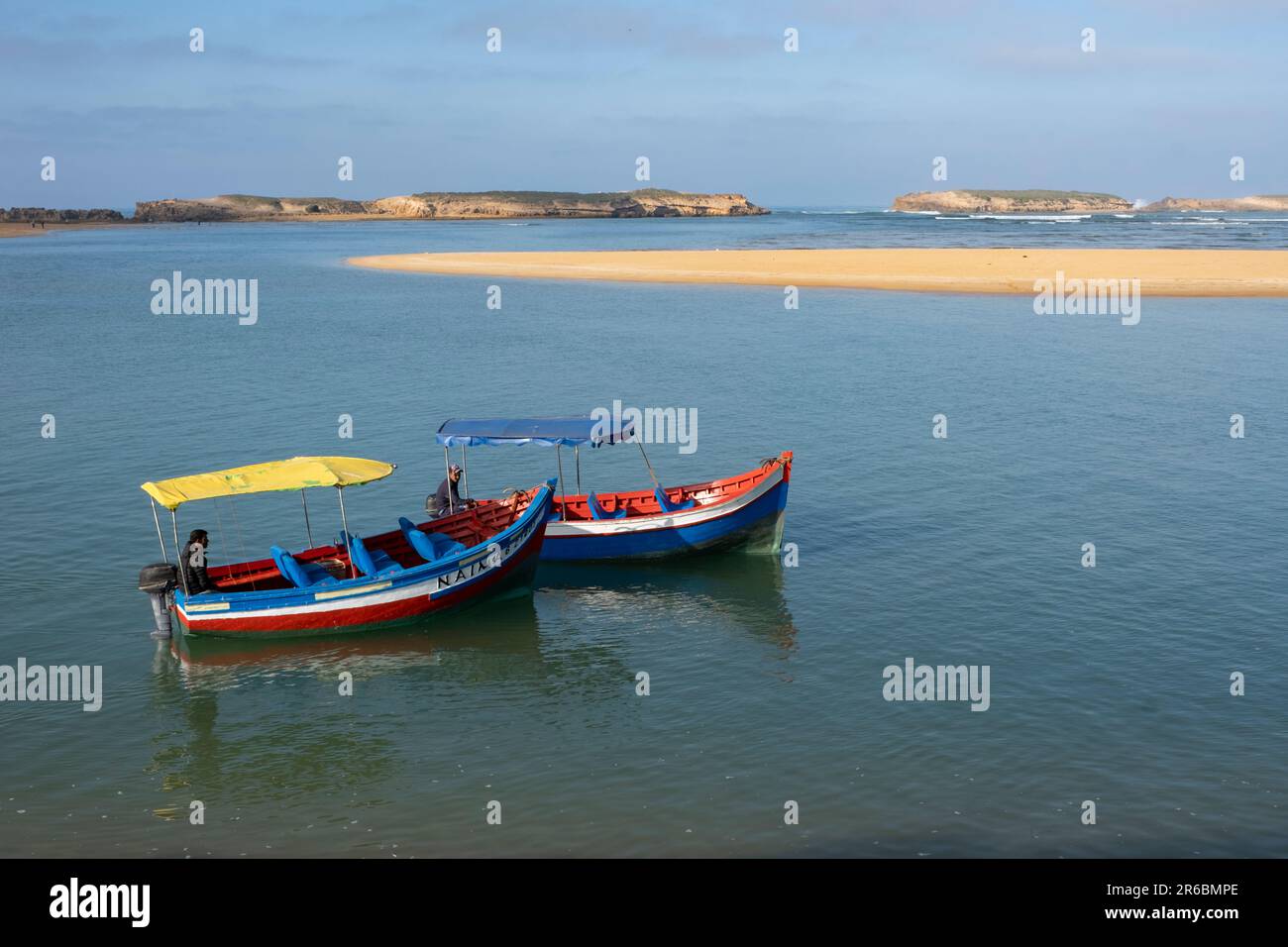 Colourful boats on the intertidal lagoon water at Oualidia in Morocco Stock Photo