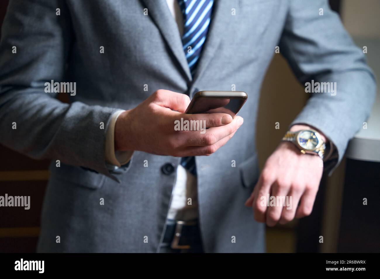 Man in business suit holds mobile phone in his hands Stock Photo - Alamy