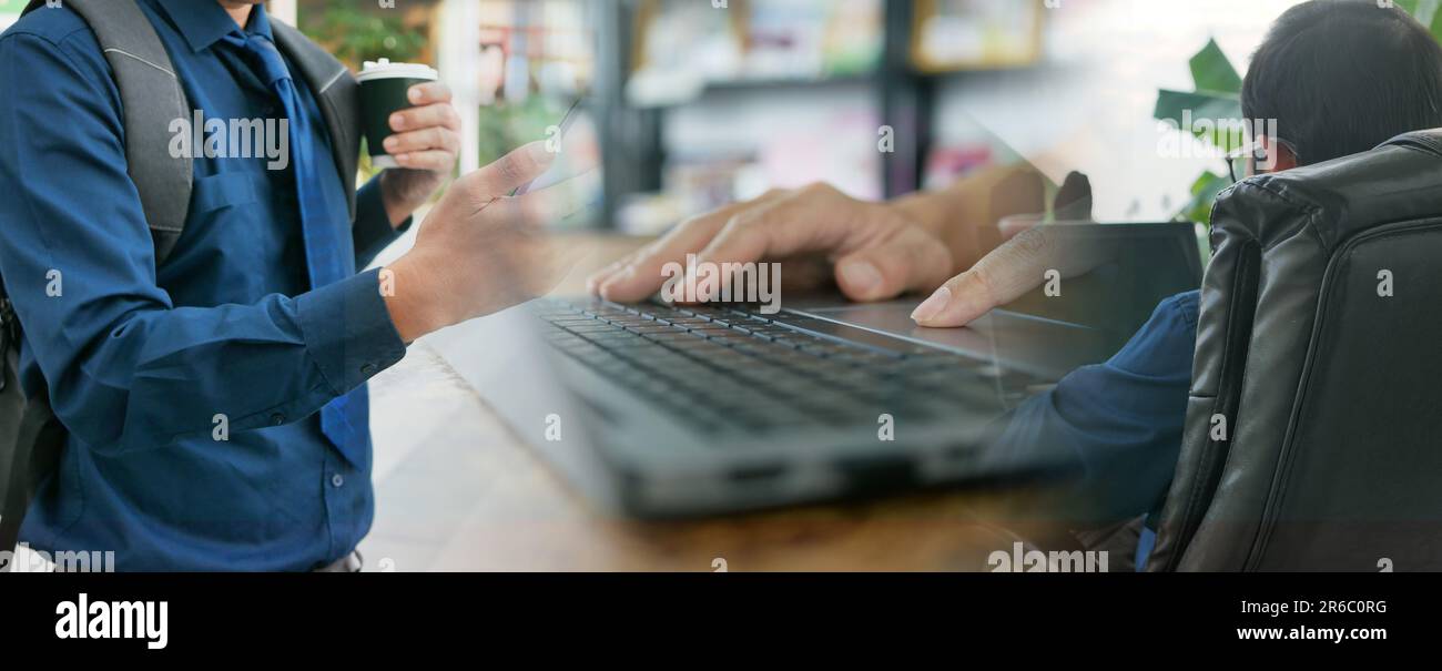 Remote and hybrid work concept. A man uses his smartphone and computer notebook to work or do his jobs from different spaces rather than from an offic Stock Photo