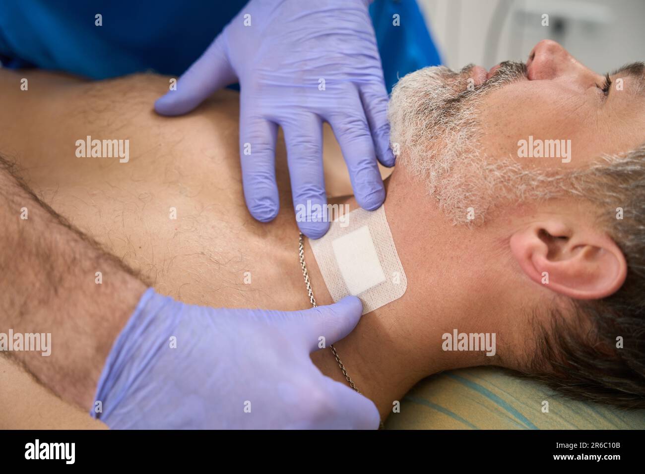 Man doctor sticking patch to patient neck after injection Stock Photo ...