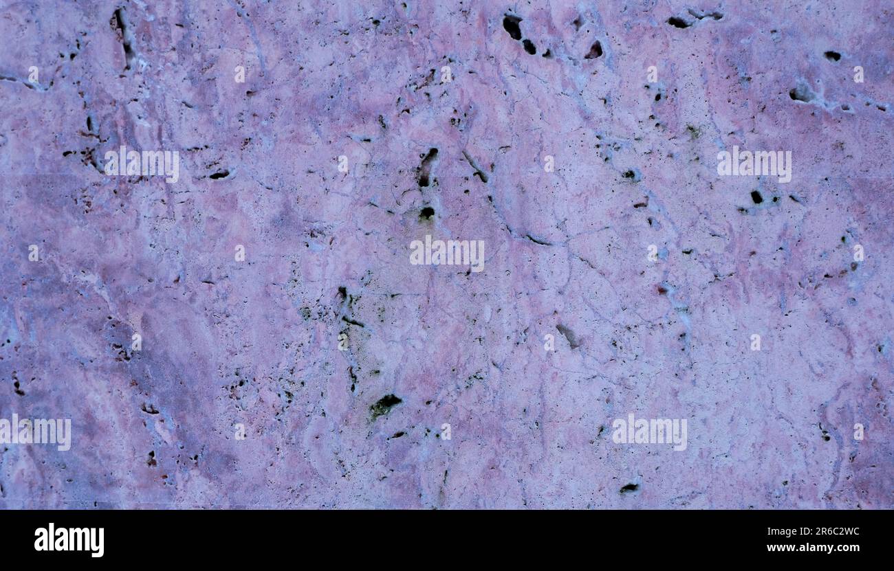 Close up of a weathered stone surface with a rough texture, featuring a