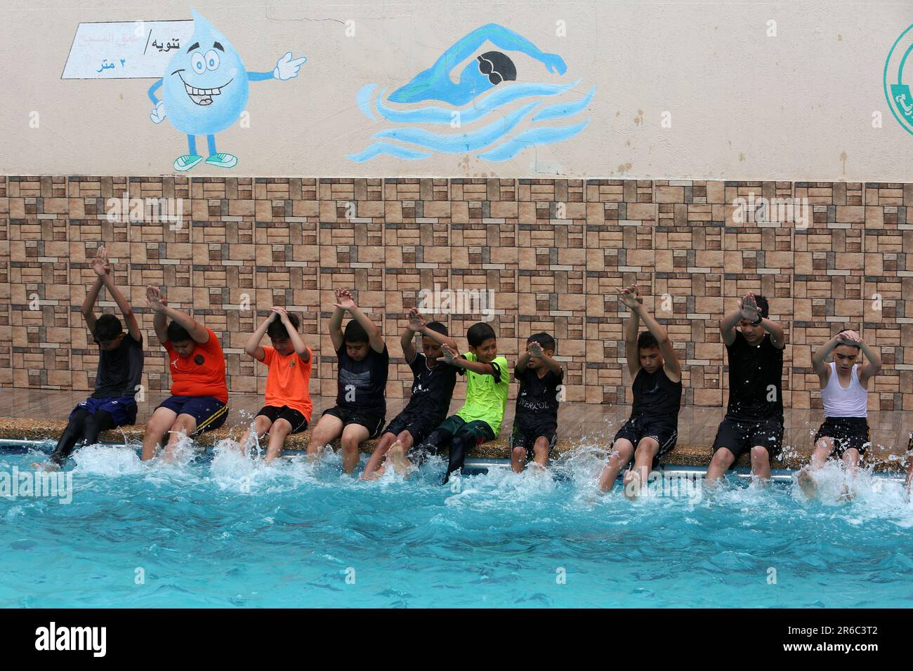 Palestinian children enjoy themselves in a cold water pool during hot