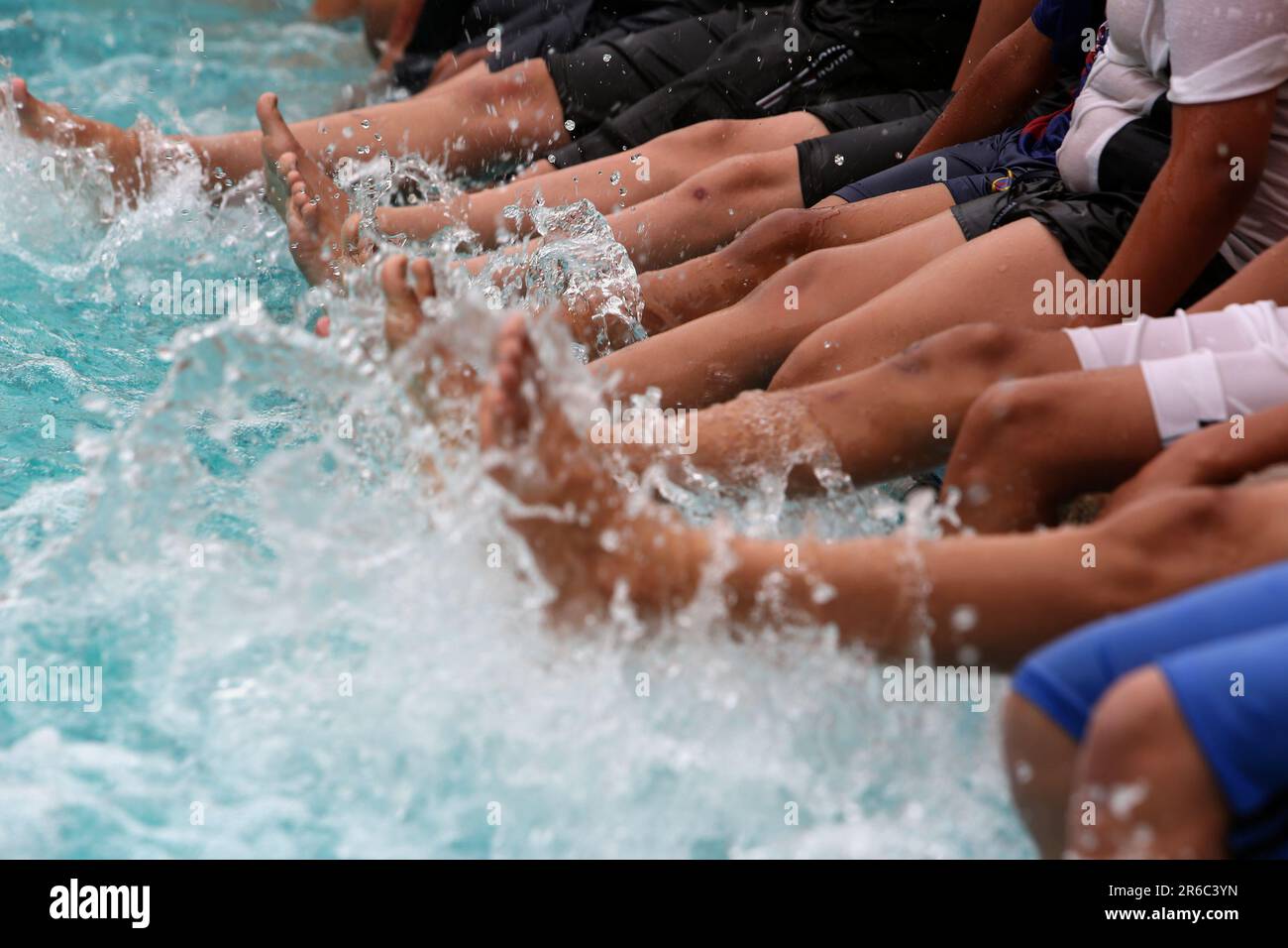 Palestinian children enjoy themselves in a cold water pool during hot