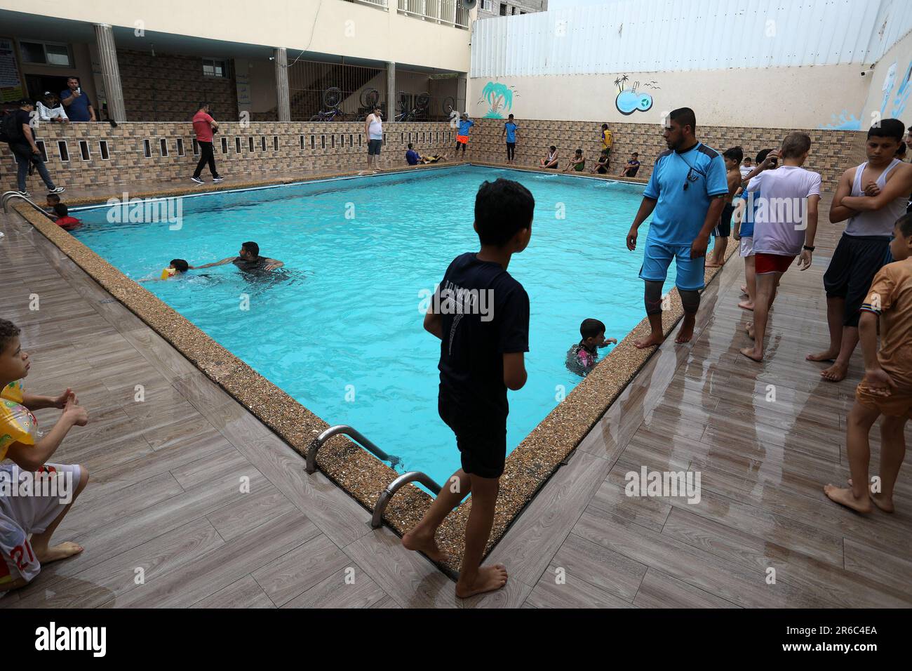 Palestinian children enjoy themselves in a cold water pool during hot