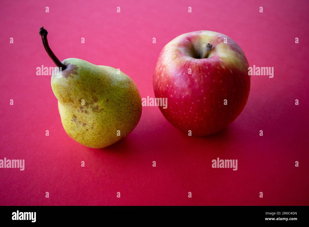 Apple and pear on a red background Stock Photo