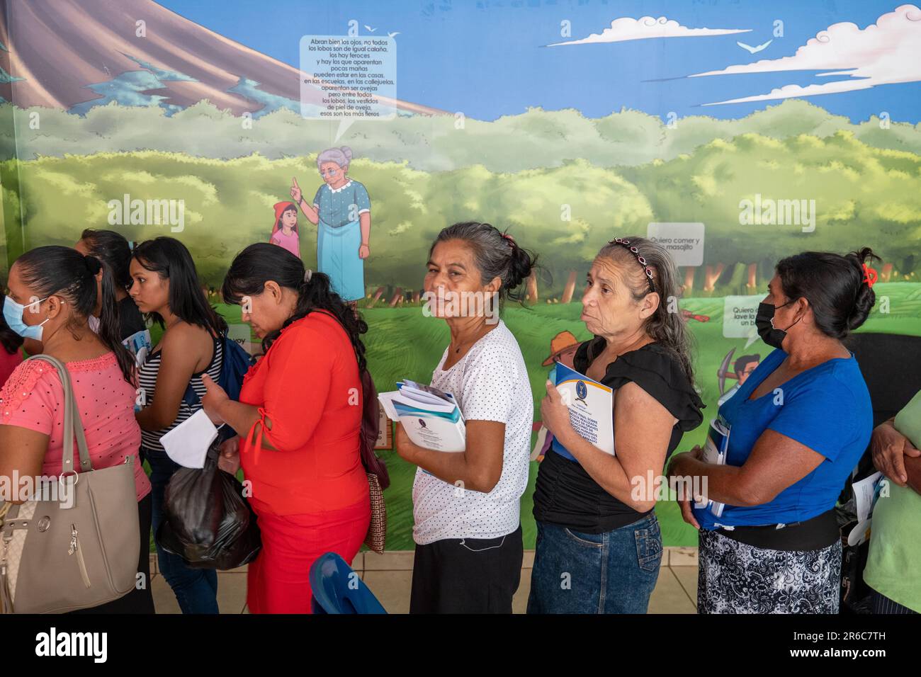 Ahuachapán, El Salvador - October 28 2022: Salvadoran Women Lining up to Receive Information Pamphlets Stock Photo