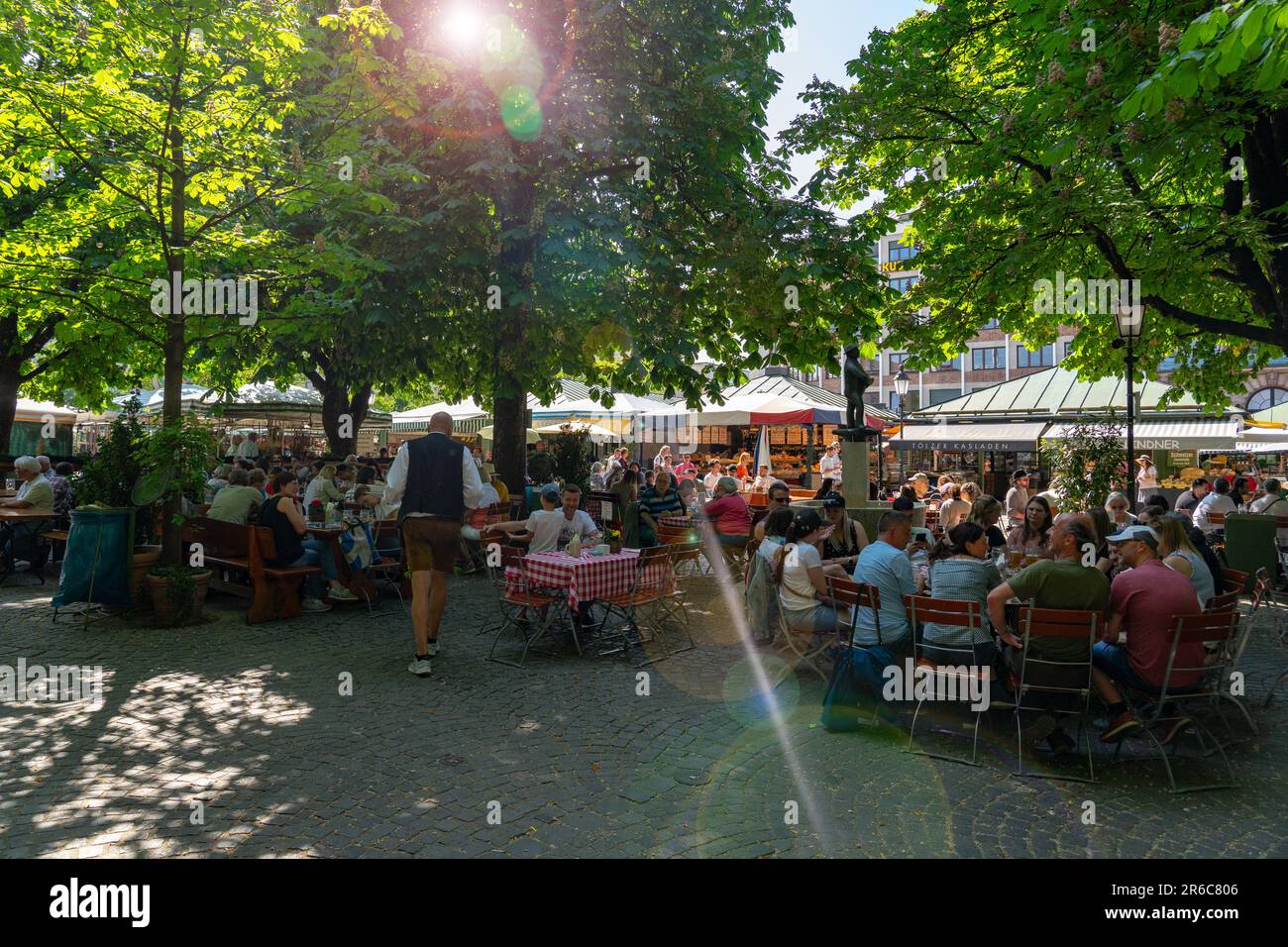 Salzburg, Austria - 06.01.2023: People eating at the traditional viktualienmarkt market in Munich crowded time in summer . Stock Photo