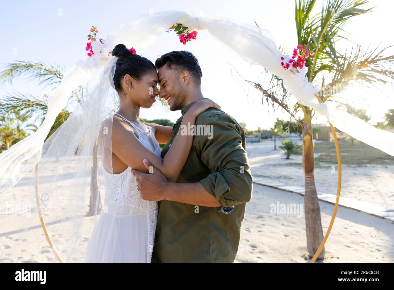 Side view of young romantic wedding couple holding face to face outdoors  Stock Photo - Alamy