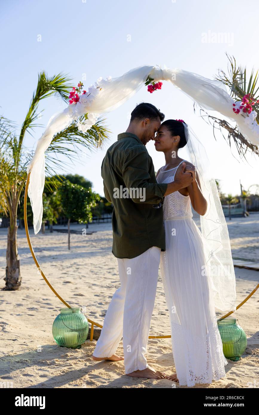 Side view of caucasian newlywed couple holding hands and standing at ...