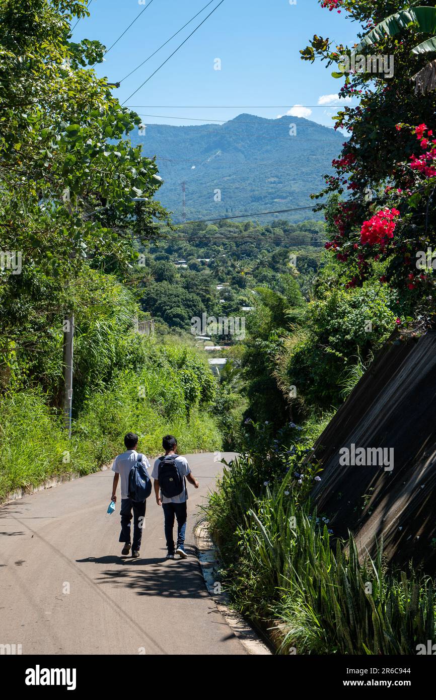 Ahuachapán, El Salvador - October 28 2022: Children Walking Down a Paved Road Surrounded by Mountain Views and Lots of Vegetation Stock Photo