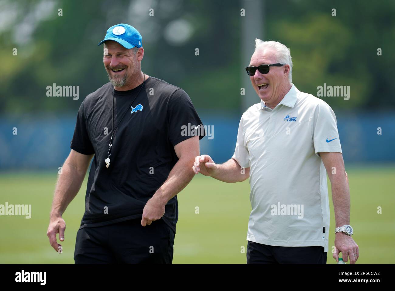 Detroit Lions head coach Dan Campbell, left, laughs with president and