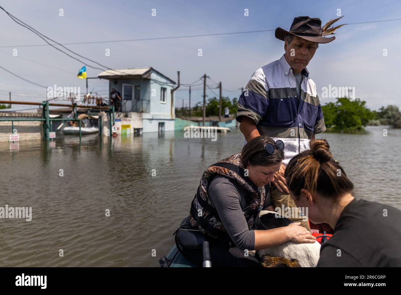 Kherson, Ukraine. 8th June, 2023. Knowable Truth pastor Bill Rigsby, 61, of Texas, pilots the boat while Ukrainian volunteers Iulia Yakovenko, 38, bottom right, and Inna Shuparska hold the dogs they rescued from a rooftop while they navigate to safety from flood waters at Kherson, Ukraine on June 8, 2023. The Kherson region is experiencing flooding from the Dnipro River after the Nova Kakhovka Dam was blown up. The Russians have been shelling the Kherson region during ongoing civilian evacuations. (Credit Image: © Daniel Carde/ZUMA Press Wire) EDITORIAL USAGE ONLY! Not for Commercial USAGE! Stock Photo