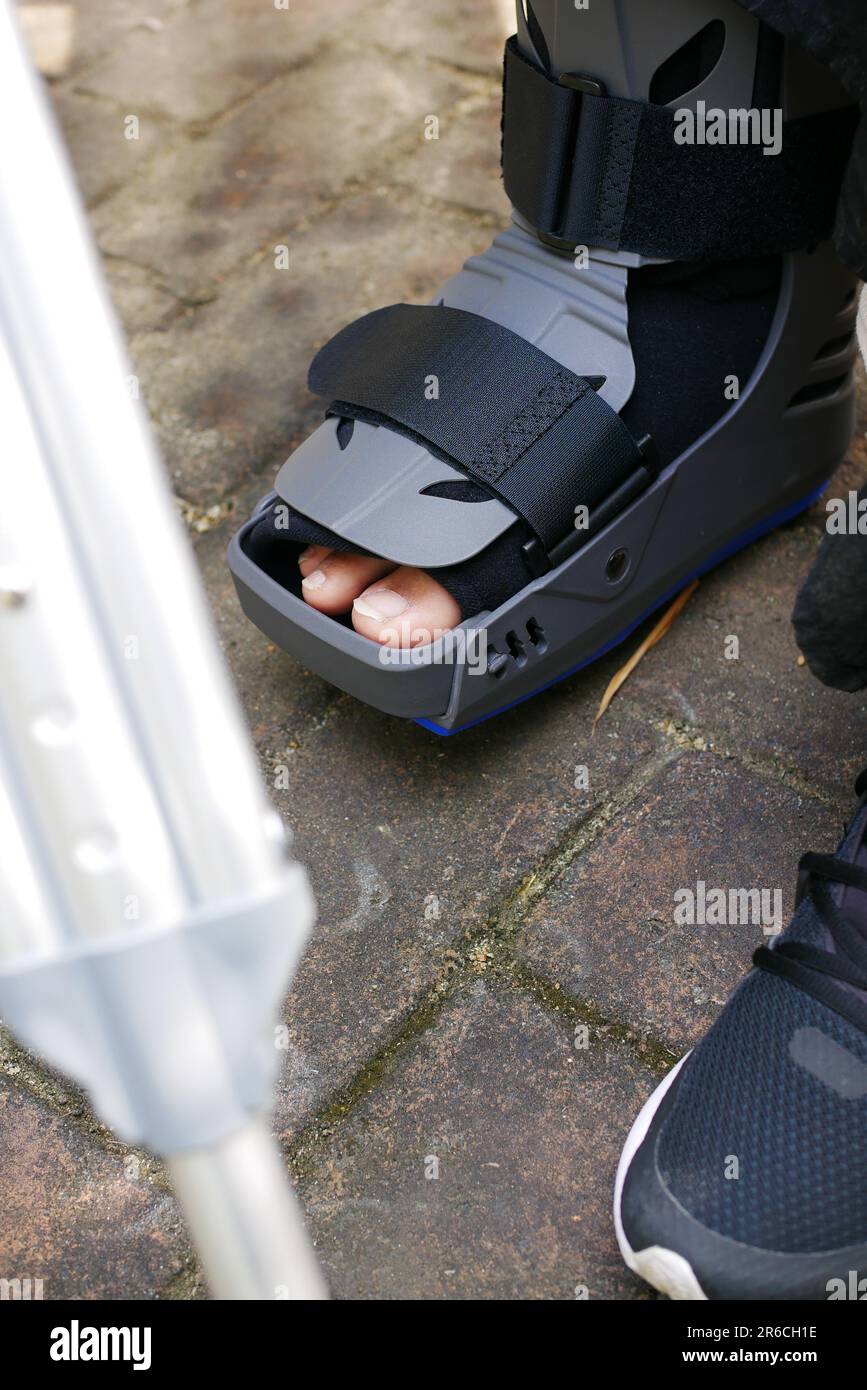 women broken feet with a grey plastic boot ankle brace injury protecting boot Stock Photo Alamy