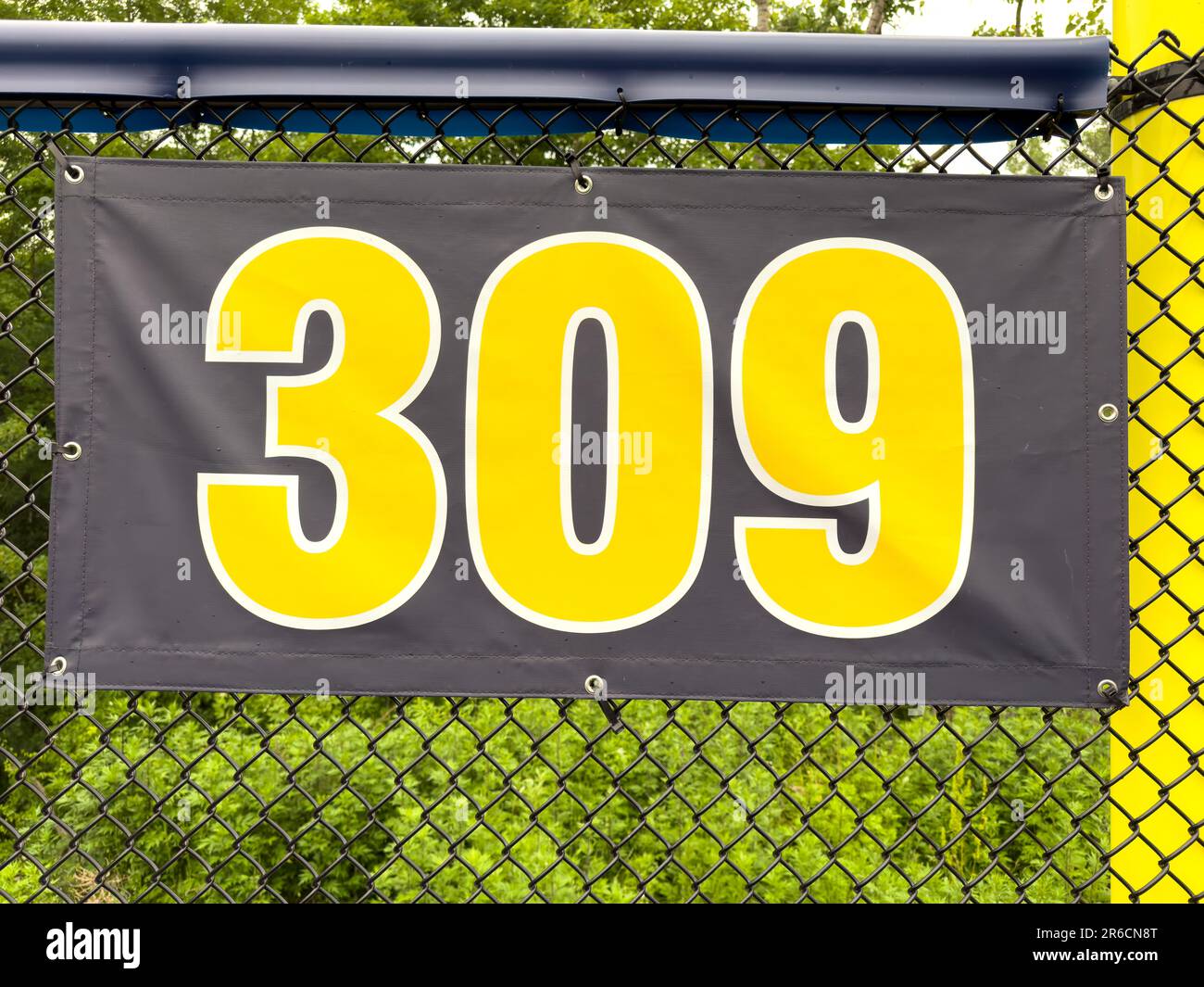 309 foot ft baseball field distance sign in yellow and black mounted on the black vinyl outfield
