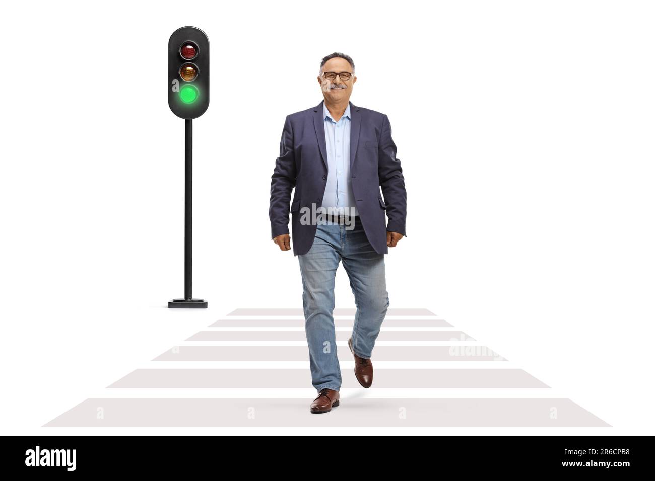 Full length portrait of a mature man in jeans and suit walking across a street at green traffic light isolated on white background Stock Photo