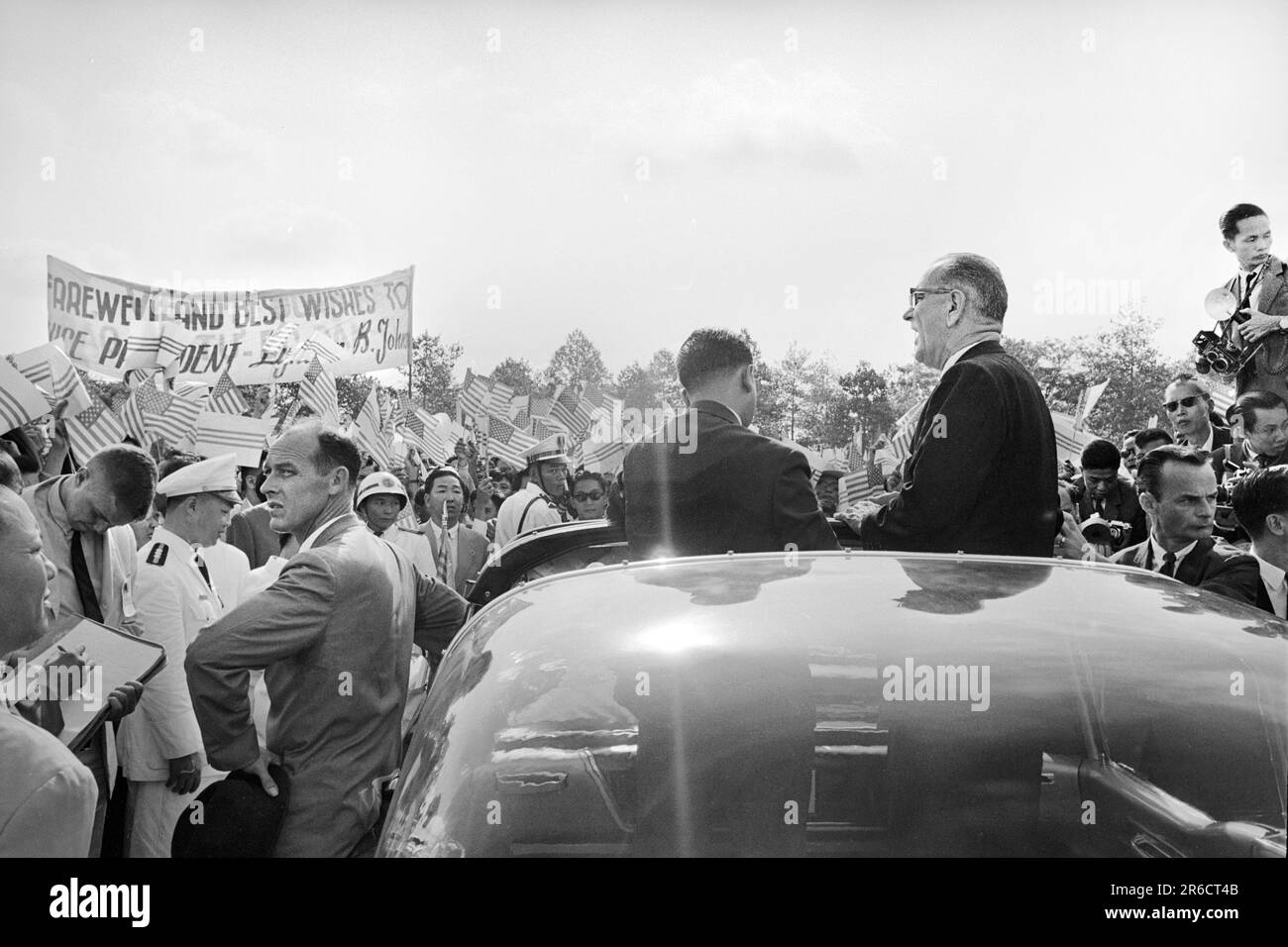 U.S. Vice President Lyndon B. Johnson, standing in a car, as Secret Service agent stands by, saying goodbye to crowds at airport, before leaving Saigon, South Vietnam, Thomas J. O'Halloran,  U.S. News & World Report Magazine Photograph Collection, May 13, 1961 Stock Photo
