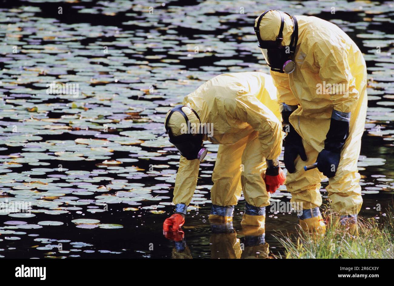 To hazmat workers wearing protective suits and breathing apparatus ...
