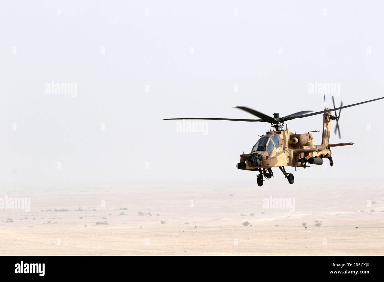 A Qatar Emiri Air Force Apache helicopter flies over the Al Qalayel