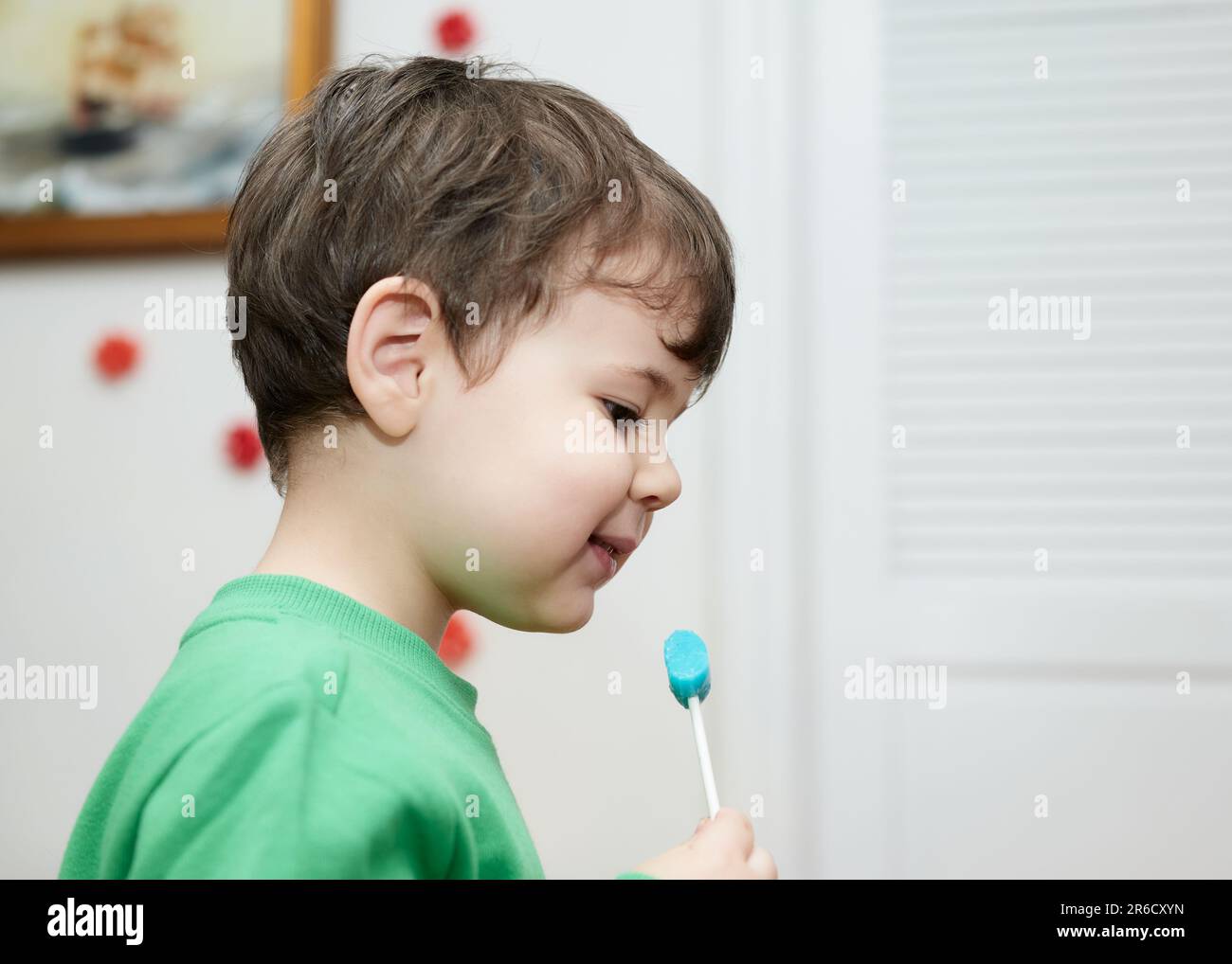 Cute baby boy enjoying a lollipop at home Stock Photo