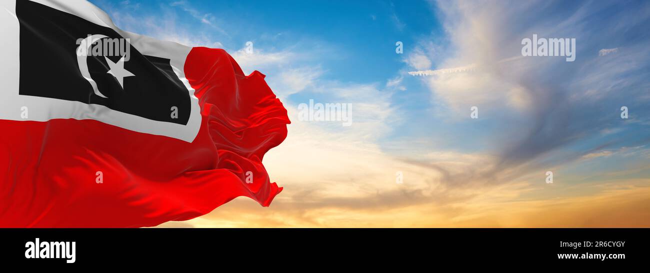 official flag of Besut, Terengganu Malaysia at cloudy sky background on sunset, panoramic view. Malaysian travel and patriot concept. copy space for w Stock Photo