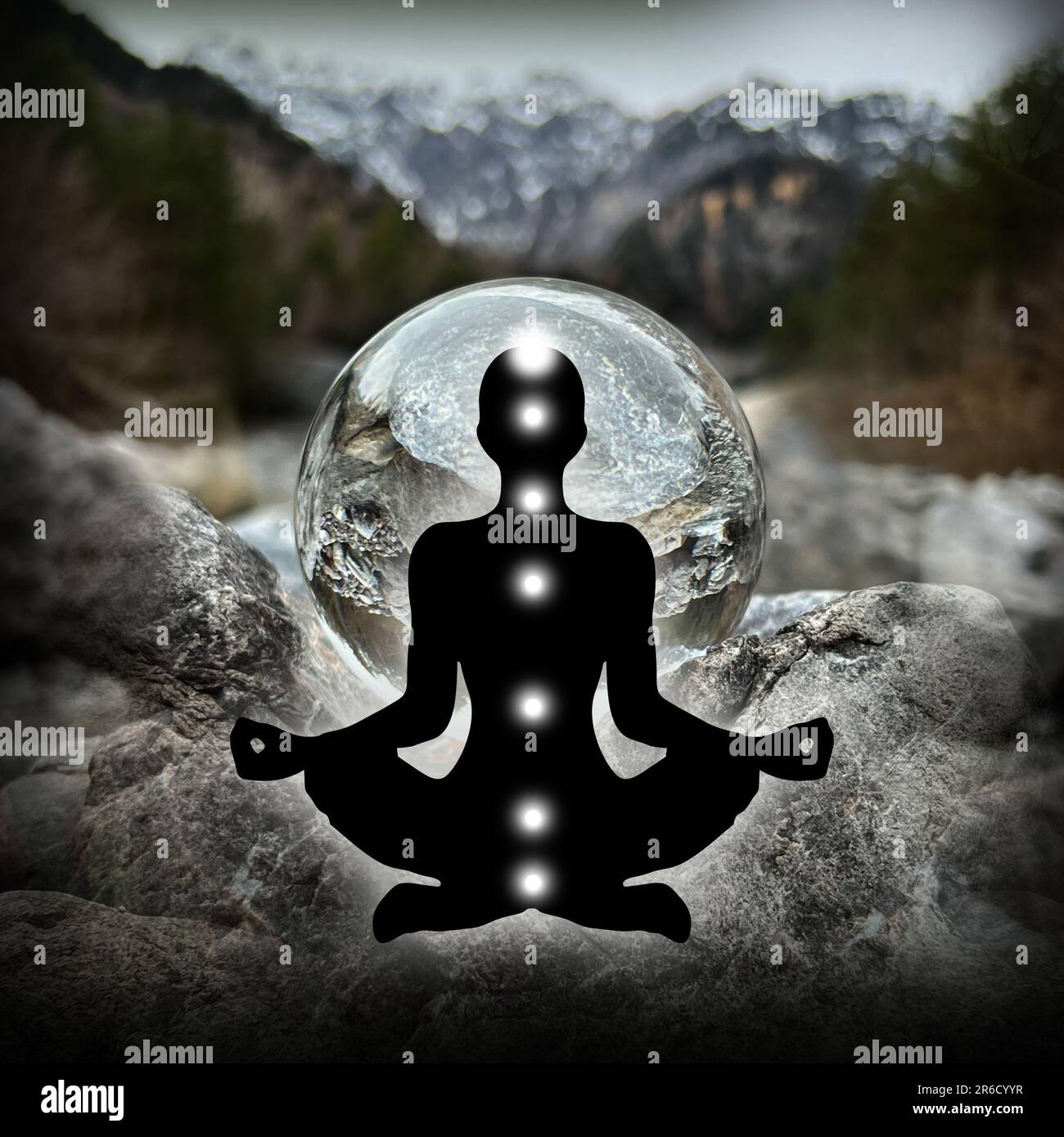 Human silhouette in yoga, lotus pose (human energy body, aura) in front of lensball, crystal ball (austrian alpine creek/landscape, Montafon) Stock Photo