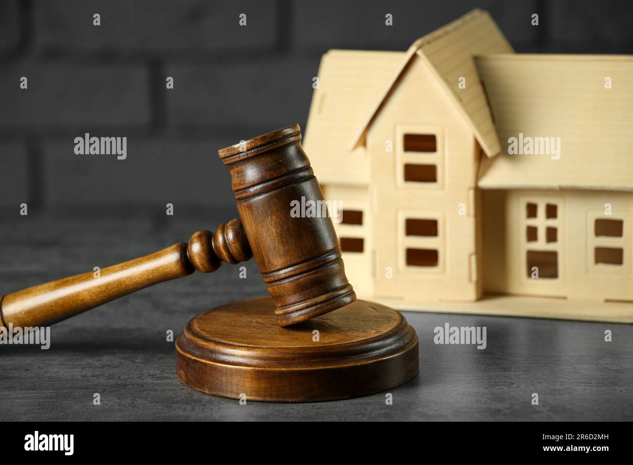Construction and land law concepts. Judge gavel with house model on grey table, closeup Stock Photo
