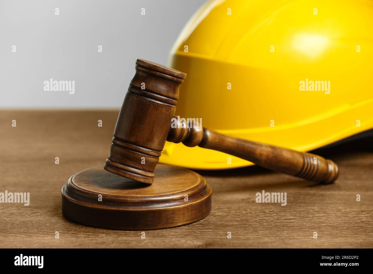 Construction and land law concepts. Gavel and hard hat on wooden table, closeup Stock Photo