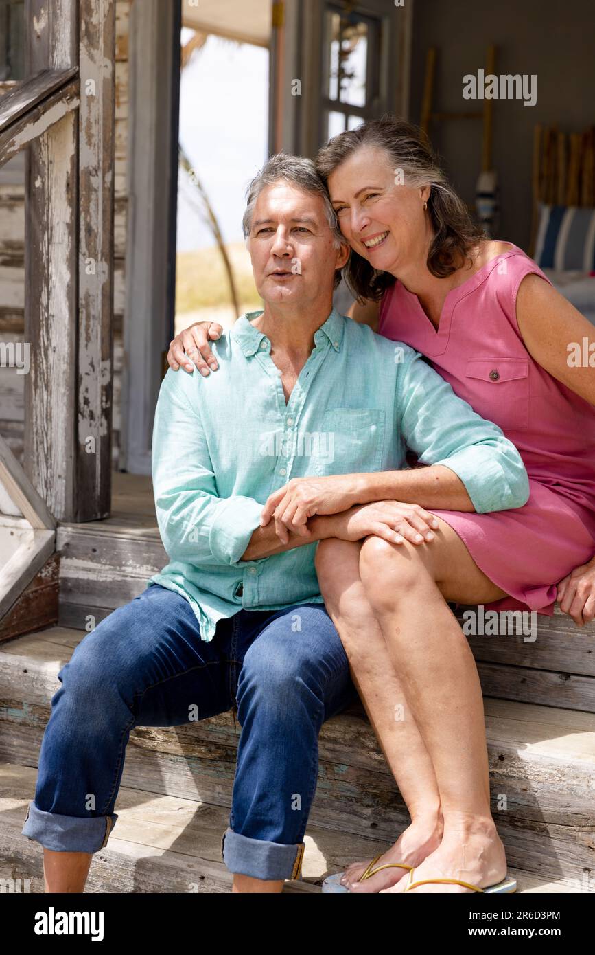 Affectionate caucasian senior couple smiling and looking away while ...