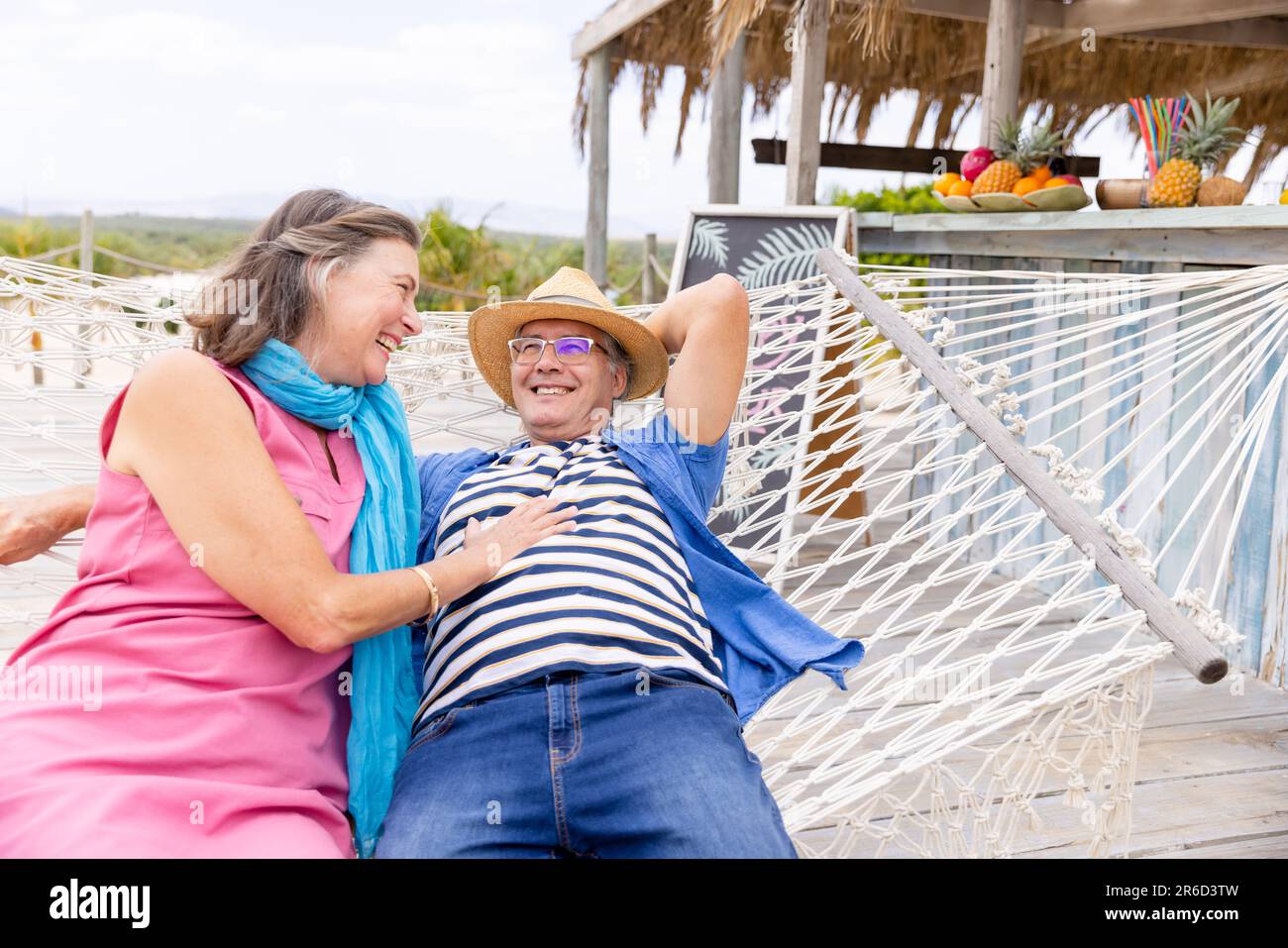 Senior couple enjoying a sunlit beach while sitting on a beach chair