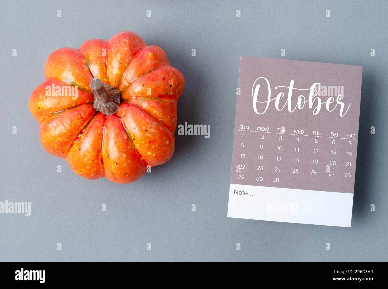 October 2023 Calendar and pumpkins on gray color cardboard background ...