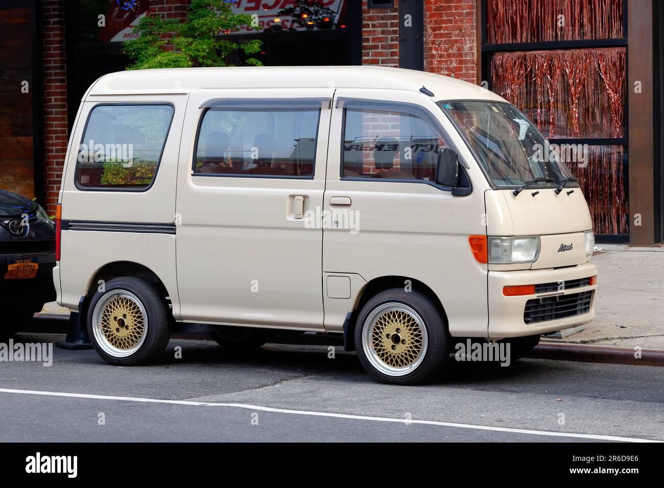 A 1990s Daihatsu Atrai minivan Japanese Kei truck parked on a street. Stock Photo
