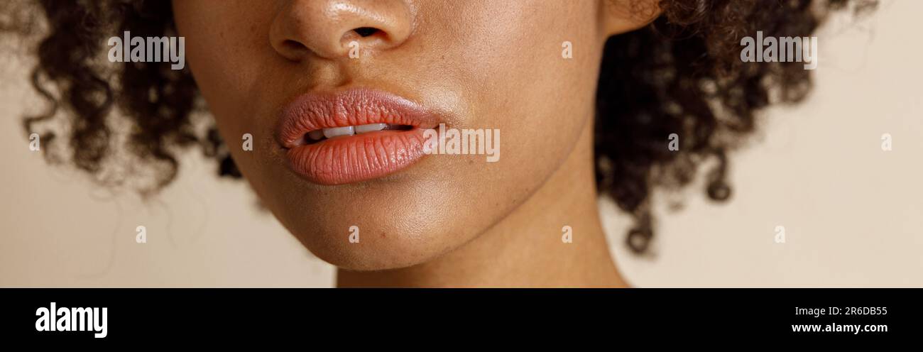 Female model with natural makeup posing on beige background Stock Photo