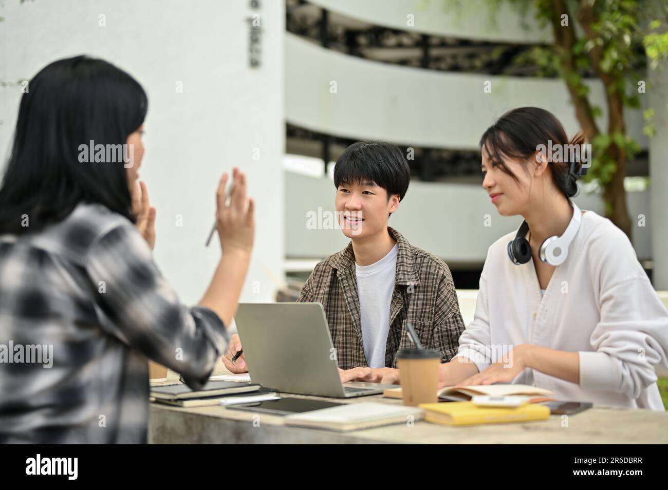 A cheerful and positive young Asian male college student is listening ...