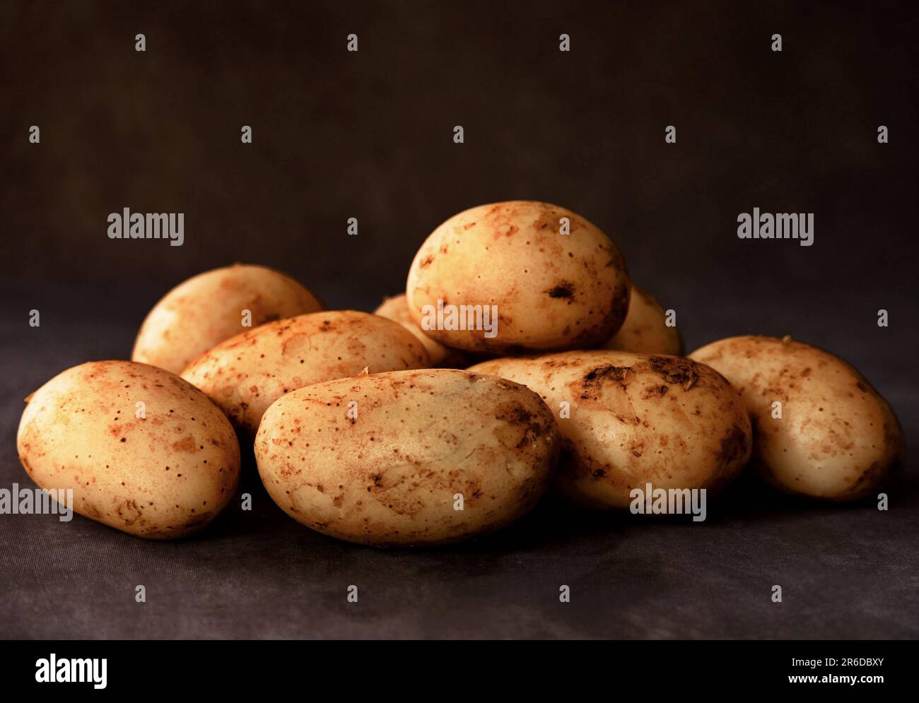 Raw potatoes on black background Stock Photo